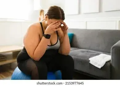 femme en tenue de sport epuisee emotionnellement, tete dans les mains