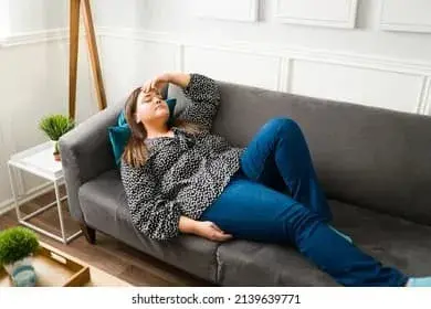 femme epuisee sur le canape, hesitation avant de sortir, manque de confiance en soi